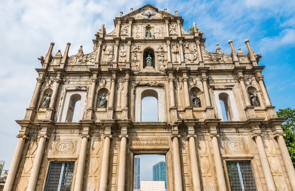 大三巴牌坊白天全景，展示精美的巴洛克式雕刻